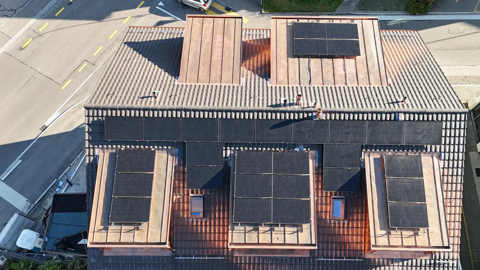 Saniertes Mehrfamilienhaus in Wetzikon von oben, Solarmodule auf Ziegeldach und neu verkupferten Lukarnen