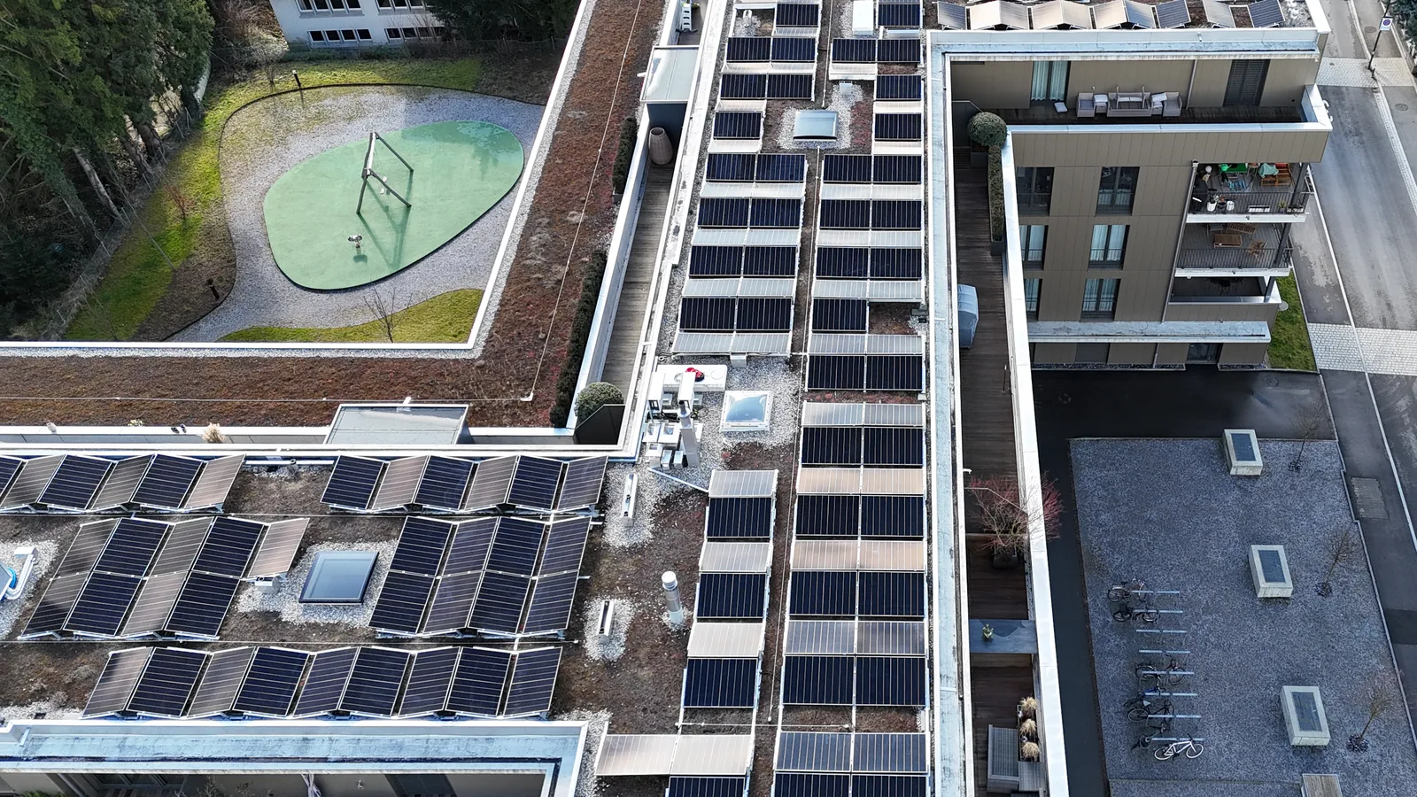 Wohnüberbauung in Uster aus der Luft, begrünte Flachdächer vollflächig mit Solarmodulen belegt